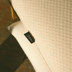 Close-up of the textured fabric slipcover with a Stitchco label.