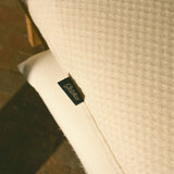 Close-up of the textured fabric slipcover with a Stitchco label.